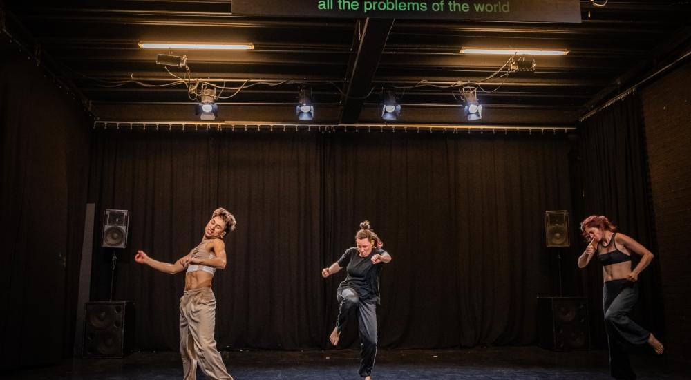Three dancers mid-movement